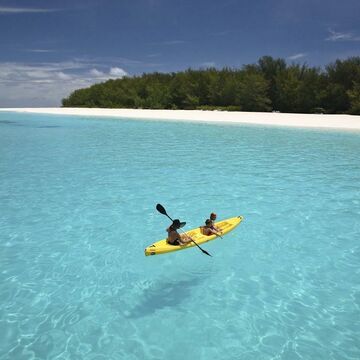 People kayaking on crystal-clear turquoise water